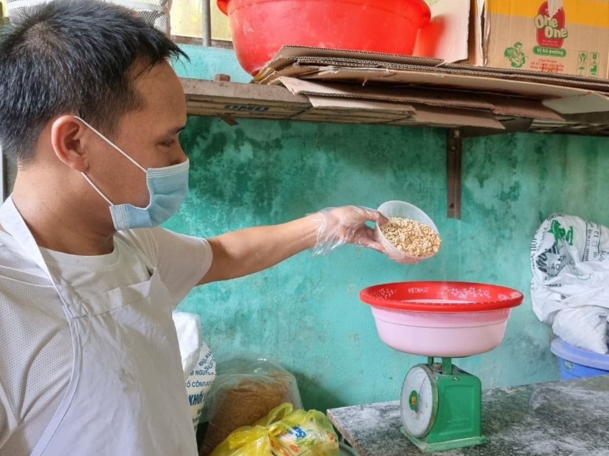 Người thợ cẩn thận cân lạc trước khi chế biến.  Người thợ cẩn thận cân lạc trước khi chế biến.