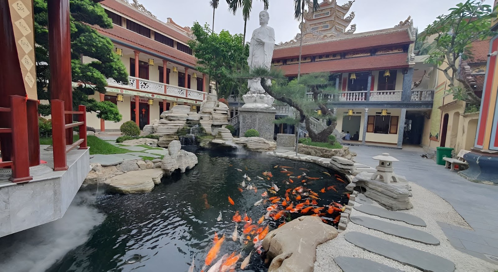 Góc check-in chùa Thanh Hà với hồ cá Koi, tượng Phật và không gian kiến trúc thanh tịnh, thu hút du khách.