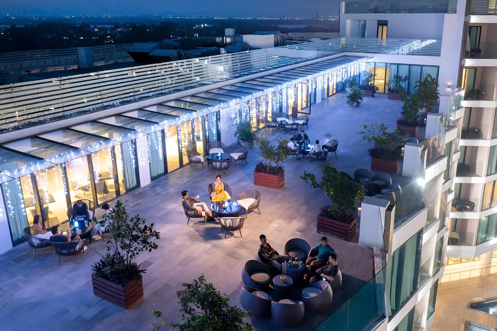 Không gian khách sạn sang trọng với khu thư giãn ngoài trời, ánh đèn ấm áp và tầm nhìn thoáng. 